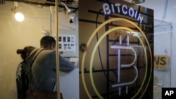 Un couple devant un distributeur de la monnaie virtuelle Bitcoin à Hong Kong, le 8 décembre 2017. (AP Photo/Kin Cheung)