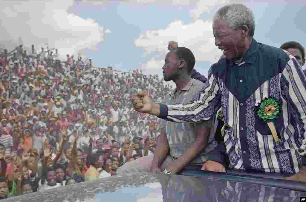 Then-African National Congress President Nelson Mandela salutes the crowd in Galeshewe Stadium near Kimberley, South Africa, Feb. 25, 1994.