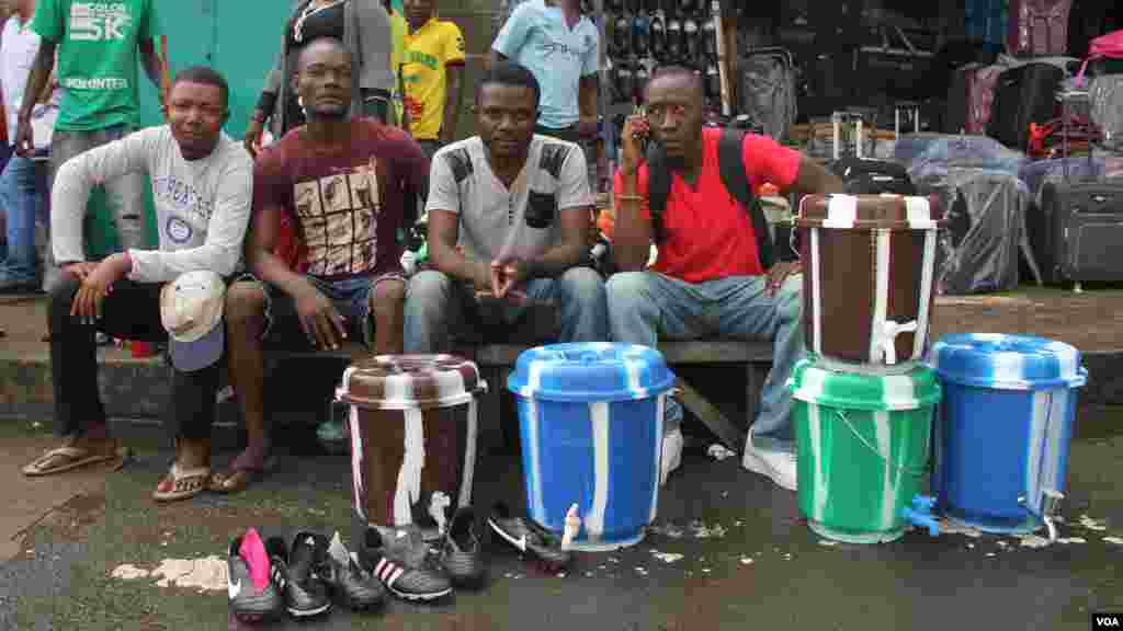 Des vendeurs des seaux utilisés pour le lavage des mains avec du savon à Monrovia, Liberia, Oct. 9, 2014. (Benno Muchler/VOA)