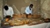 Des archéologues égyptiens examinent un sarcophage en bois découvert dans une tombe de l'ère pharaonique à Draa Abul Naga, près de Louxor, Egypte, le 18 avril 2017.