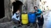 FILE - Boys are pictured beside a cart they use to carry water back to their home in the east Aleppo neighborhood of al-Mashatiyeh, Syria, in this handout picture provided by UNHCR, Jan. 4, 2017. 