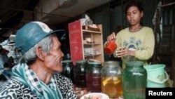 រូបឯកសារ៖ អតិថិជន​ម្នាក់​រង់ចាំ​អ្នក​លក់​ដួស​ស្រា​ស​ឲ្យ នៅ​តៀម​លក់​ស្រា​មួយ​ក្នុង​រាជធានី​ភ្នំពេញ។ 