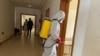 FILE - A health agent wearing protective equipment disinfects the corridors amid the spread of the coronavirus, at an hospital in Douala, Cameroon, April 27, 2020.