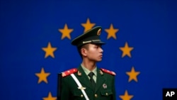 一名中國警察站在歐盟駐華代表團辦公室外的歐盟旗幟前。