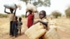 FILE - Children carry belongings as they go to a refugee camp in South Sudan, May 2, 2012. The United Nations refugee agency reports that renewed violence has trapped more than 100,000 residents and refugees in Yei, which now is surrounded by government forces.