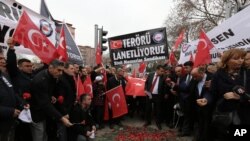 Des fonctionnaires turcs tiennent une bannière qui lit "Nous condamnons le terrorisme», sur le site d'une explosion qui avait tué 28 personnes à Ankara, le 20 février 2016.