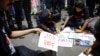 FILE - Orang-orang membuat poster selama protes yang mengecam pemerkosaan dan pembunuhan seorang dokter magang di rumah sakit milik pemerintah, di Kolkata, India, 15 Oktober 2024.
