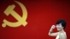 在上海的中共第一次代表大会会址，一名女子在中国共产党党旗下摆出宣誓姿势 （2012年7月1日）
