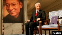 នាយកគណកម្មការណូបែល Norwegian លោក Thorbjoern Jagland សំឡឹងមើល​សញ្ញាបត្រណូបែល​នៅលើ​កៅអីទំនេរដែល​ជ័យលាភីសន្តិភាព​ណូបែល​ចិន​ដែល​ត្រូវ​បាន​ឃុំឃាំងឆ្នាំនេះលោក Liu Xiaobo ​នឹង​អង្គុយ។