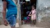 A girl helps her mother to remove mud from her house after Hurricane Matthew flooded their home in Les Cayes, Haiti, Oct. 6, 2016. 