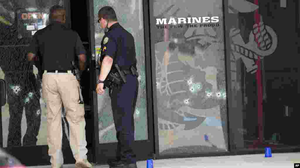 Les agents de police entrent dans le centre de Carrière des forces armées par une porte criblé des balles après qu'un homme armé a ouvert le feu sur le bâtiment le 16 Juillet 2015 à Chattanooga, au Tennessee.