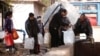 People queue as they fill containers with water in the government controlled al-Rabwah area, a suburb of Damascus, Jan. 10, 2017. 