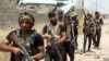 FILE - Iraqi Shi'ite fighters from the Popular Mobilization units deploy as they fight alongside Iraqi forces against the Islamic State jihadist group, June 9, 2015. 