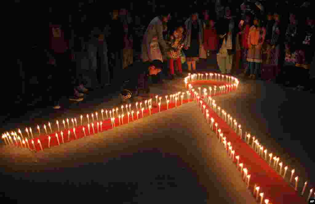 An Népal, des femmes et des enfants de "Maiti Nepal", un centre de réadaptation pour les victimes de trafic sexuel, ont allumé des bougies à la veille de la Journée mondiale du sida à Katmandou, 30 novembre 2015. 