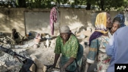 Habiba, une concasseuse de gravier qui pense avoir entre 50 et 60 ans, et Idjele, 38 ans, choisissent des dalles de pierres dans une charrette près de la Cité internationale des affaires à N'Djaména, le 12 avril 2021.