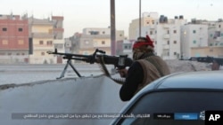 Un homme armé à un passage de sé, Jan. 11, 2017, by the so-called Islamic State Group in Sinai, a militant organization, shows a deadly attack by militants on an Egyptian police checkpoint, Monday, Jan. 9, 2017, in el-Arish, north Si