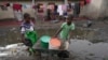 Des enfants vont chercher de l'eau à l'aide d'une brouette dans le township de Lilanda à Lusaka, en Zambie, le samedi 9 mars 2024. (AP Photo/Tsvangirayi Mukwazhi)