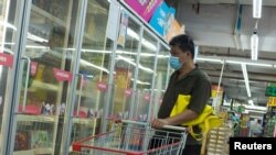 Un homme regarde des produits alimentaires surgelés dans un supermarché à Pékin, en Chine, le 13 août 2020.