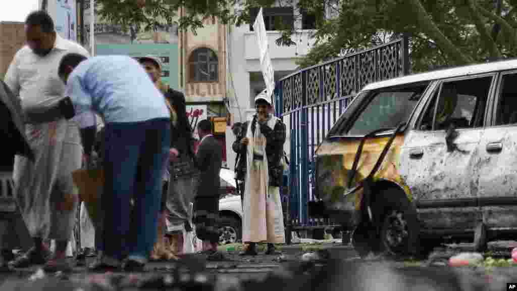 Les autorités de la sécurité collectent les débris d’une explosion causée par un attentat suicide à Sanaa, Yémen, jeudi le 9 octobre 2014. AP Photo