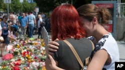 Des passants rendent hommage aux victimes de l'attentat de Munich, Allemagne, le 24 juillet 2016. 