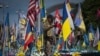 Seorang tentara relawan dari Legiun Asing Ukraina mengambil video di lokasi monumen peringatan sementara untuk tentara Ukraina dan asing yang telah tewas dalam perang di alun-alun Hari Kemerdekaan di Kyiv, Ukraina, pada 23 Juli 2024. (Foto: AP/Efrem Lukatsky)