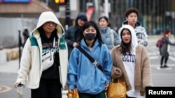 芝加哥中國城的一位女性1月30日戴口罩步行。