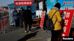北京市民在進入一個市場前用手機刷健康碼。（2021年1月11日）