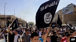 Des manifestants scandent des slogans pro-Etat Islamique, portant un drapeaudu groupe djihadiste devant le siege du gouvernement de Mosoul, à 360 kms northwest de Baghdad.