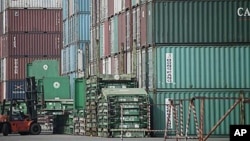 圖為中國上海一個港口附近的叉車正在搬運集裝箱資料照。